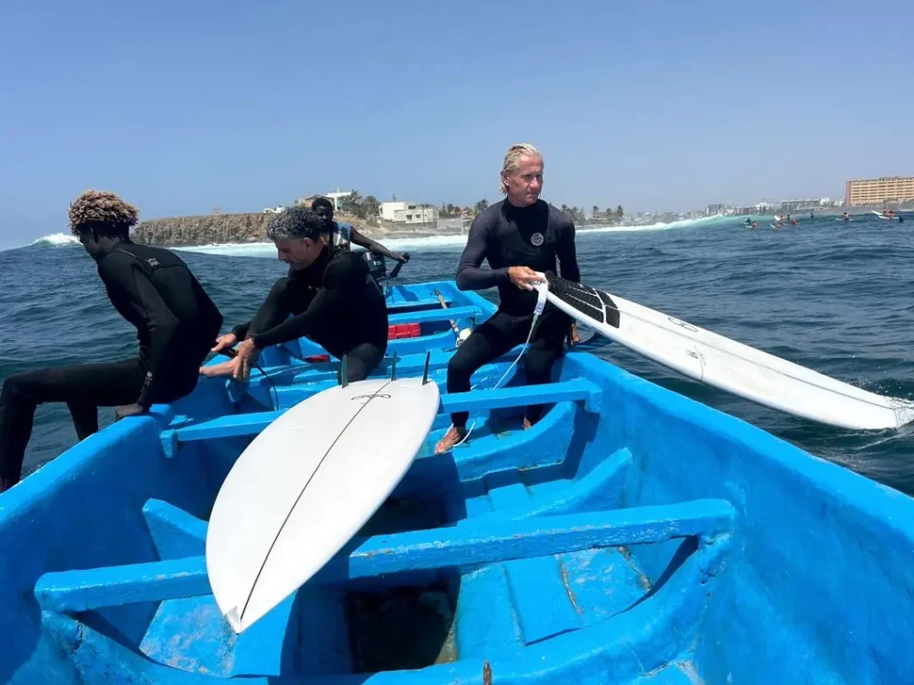 des surfeurs se préparent à se mettre à l'eau à Ngor au Sénégal, depuis le beateau qui les amène près du pic